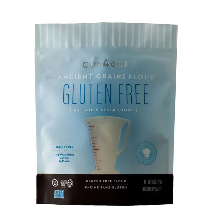 A light blue CUP4CUP bag labeled "Gluten Free" contains CUP4CUP ANCIENT GRAINS FLOUR. The packaging displays a measuring cup and notes it's a dairy-free all-purpose flour with 24g whole grains per serving.