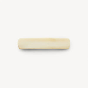 The MACHETE - NO 3 BARRETTE IN ALABASTER is a smooth, rectangular, cream-colored handmade hair accessory crafted from premium cellulose acetate with rounded edges, displayed on a plain white background.