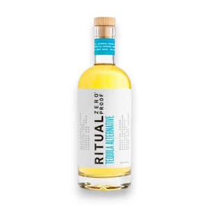 A bottle of RITUAL ZERO PROOF - TEQUILA ALTERNATIVE by RITUAL ZERO PROOF, a non-alcoholic tequila with a white label, blue accents, and a wooden cap, standing upright on a white background.