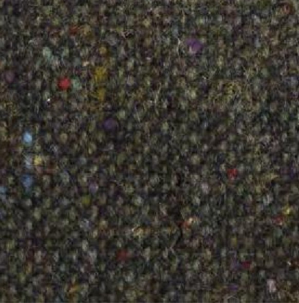 A close-up of the WIGENS Ivy Contemporary Donegal Tweed Cap in Dark Green highlights its authentic Donegal Tweed texture, featuring tiny flecks of red, yellow, blue, and purple woven throughout a richly mottled dark green background.