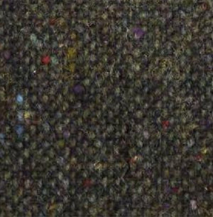 A close-up of the WIGENS Ivy Contemporary Donegal Tweed Cap in Dark Green highlights its authentic Donegal Tweed texture, featuring tiny flecks of red, yellow, blue, and purple woven throughout a richly mottled dark green background.