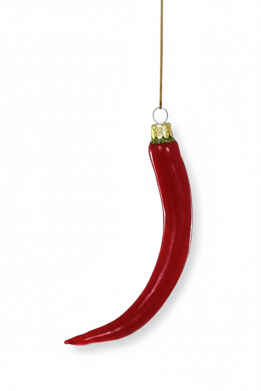 A shiny red CHILI PEPPER ORNAMENT made of glass hanging from a gold string.