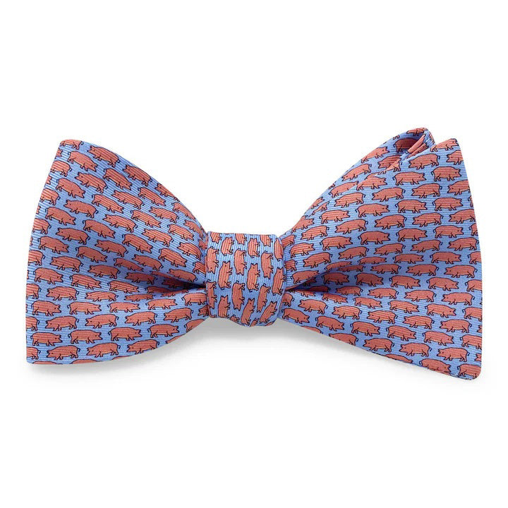 The BIRD DOG BAY PETER-BLAIR Tiny Swine Silk Bow Tie in Blue features a handmade design with small red pigs facing left on vibrant blue silk. Adjustable for a perfect fit.