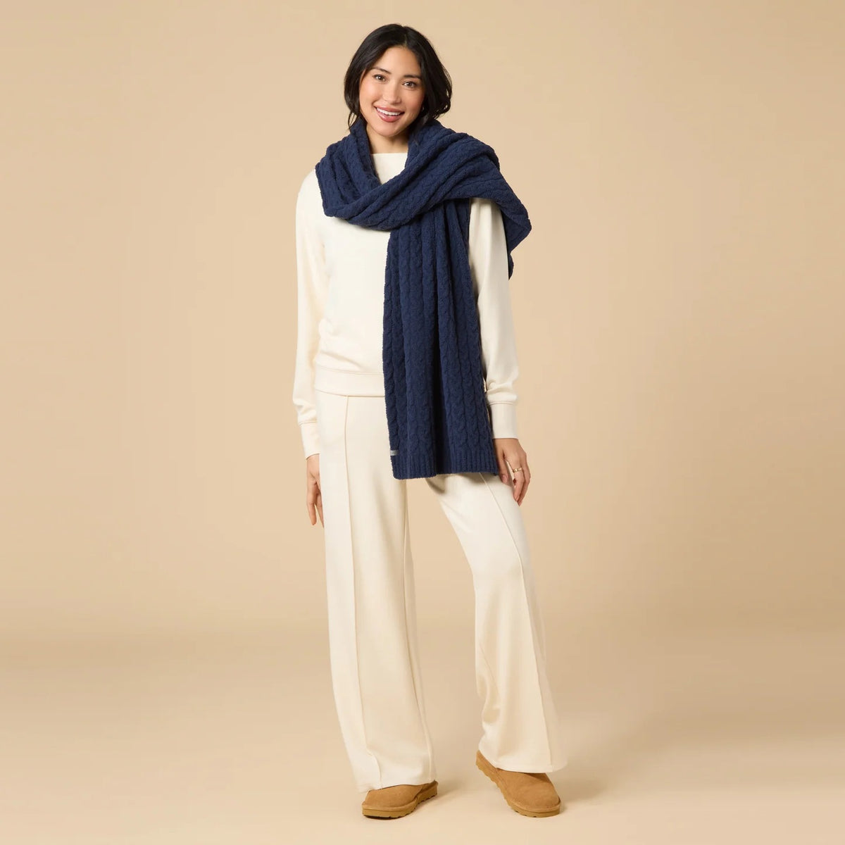 A dark navy blue SOFTIES - CABLE KNIT MARSHMALLOW SCARF draped in a loop.