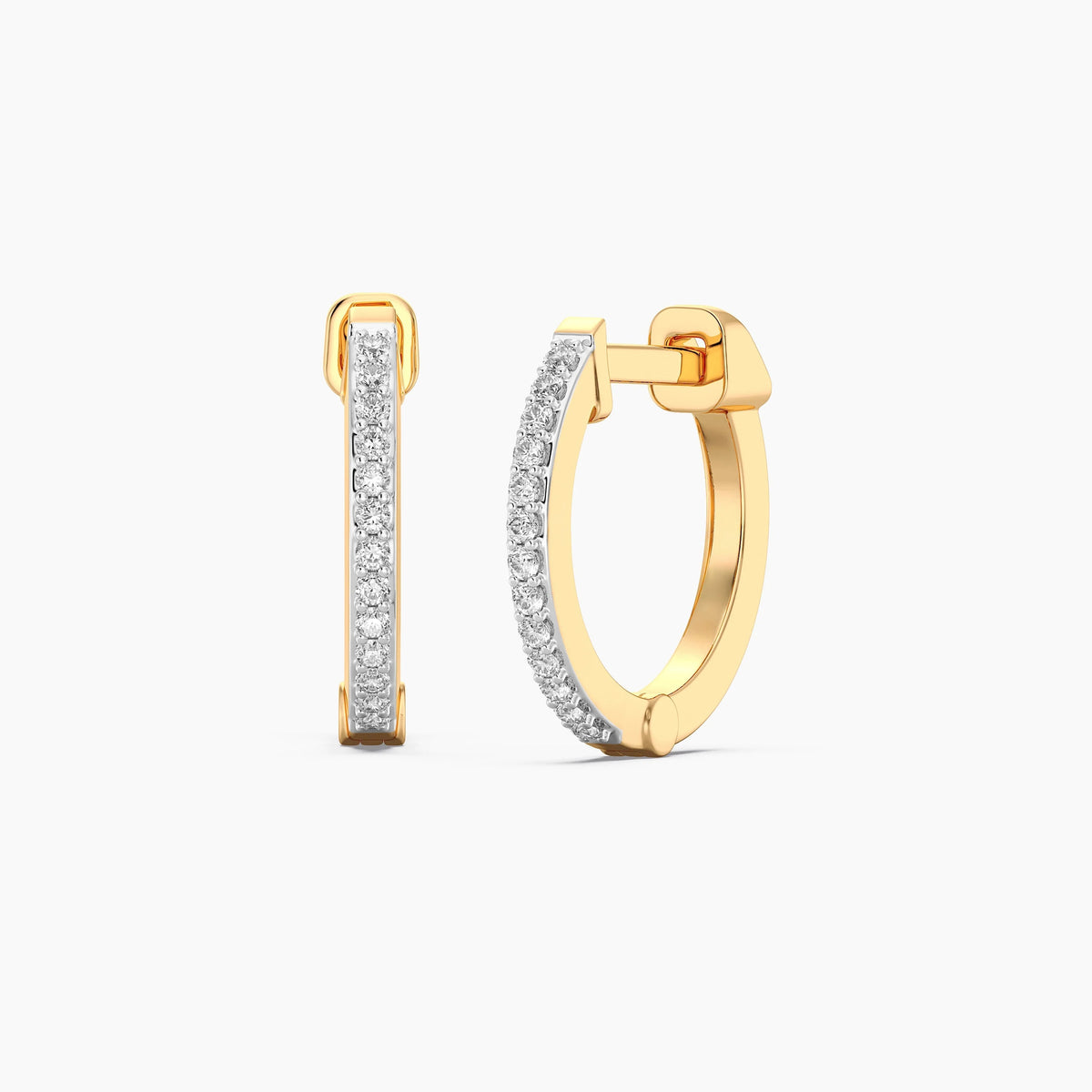 A close-up of a woman’s ear wearing the ELLA STEIN - CLASSIC PAVE DIAMOND HUGGIE EARRINGS (LARGE) in gold, adorned with natural diamonds. Her hand, featuring neatly manicured nails, gently touches her hair near her ear.