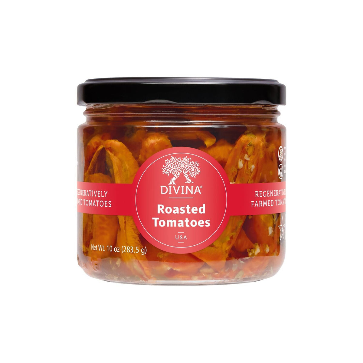 A flatbread topped with lettuce, cucumber, feta, olives, onions, and marinated tomatoes rests on parchment paper next to a jar of DIVINA - ROASTED TOMATOES by DIVINA on a wooden surface.