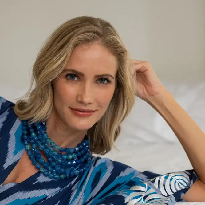 The FAIRCHILD BALDWIN - THE BELLA NECKLACE showcases layered strands of iridescent green Italian resin beads with a faceted design for a shimmering effect, finished with a smooth light green clasp that complements its vibrant hues.