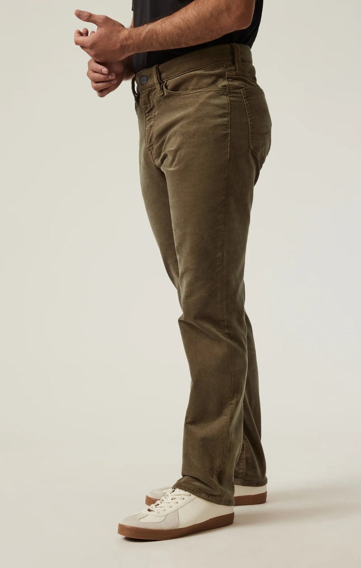 Man wearing 34 HERITAGE - COURAGE STRAIGHT LEG CORDUROY PANTS IN TOBACCO and white sneakers.