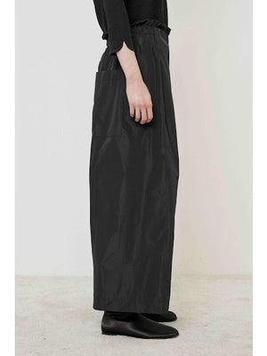A flat, solid brown surface fills most of the image with a narrow black strip along the bottom edge, evoking the minimalist style of the MEIMEIJ - WIDE LEG PANT by MEIMEIJ.