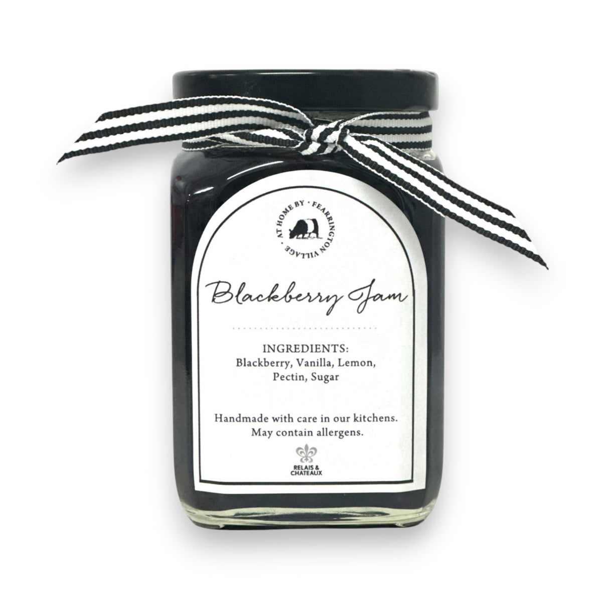 The FEARRINGTON SIGNATURE COLLECTION - FEARRINGTON HOUSEMADE BLACKBERRY JAM features a stylish black and white striped ribbon tied around the lid. The label reveals ingredients including blackberry, vanilla, lemon, pectin, and sugar. This handcrafted jam is made with meticulous care and is an ideal hostess gift. Please be aware that it may contain allergens.
