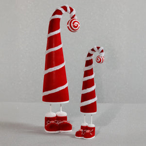 Two ZODAX WHIMSICAL CANDY CANE HAT FIGURES, each 3 in x 13 in, feature tall red spiraled hats with white trim and peppermint tops, plus red shoes with white fur and laces, standing on a sparkling light gray surface.