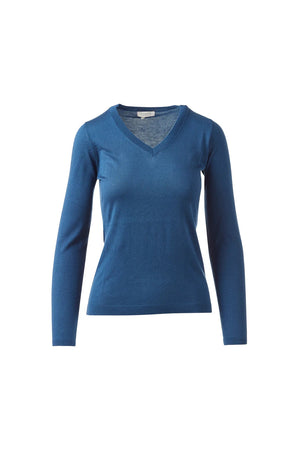 A woman with dark hair pulled back smiles in a KINROSS CASHMERE Fitted Vee Neck Silk Cashmere Sweater in blue and black pants, standing against a plain white background.