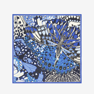 A close-up of the INOUI EDITIONS PAPILLON silk scarf in blue, featuring a smooth, shiny texture and abstract butterfly-inspired pattern in blue, black, and cream—a versatile accessory crafted in India by INOUI.