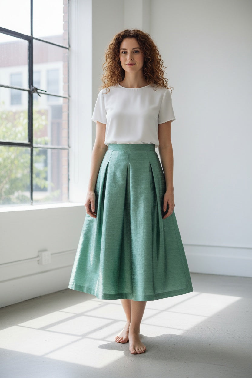 The MIDI STRUCTURED SKIRT by ALYKI LABORATORIO is a high-waisted, midi-length piece with a flared silhouette, showcasing a vibrant pink and red abstract floral print on a white background.