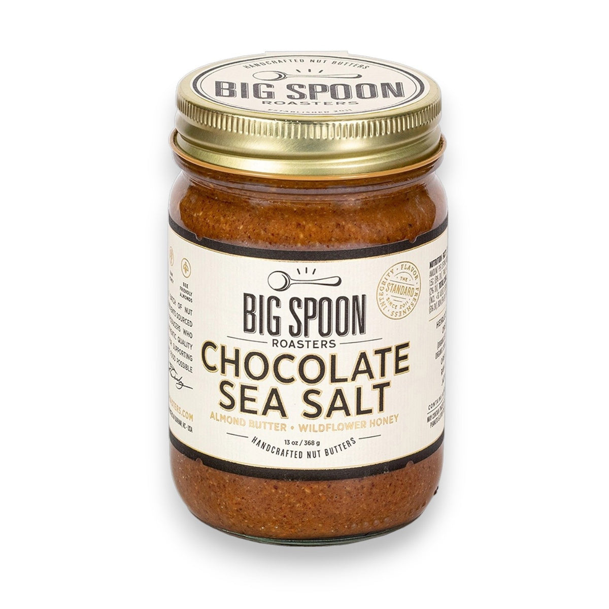 A jar of BIG SPOON ROASTERS Chocolate Sea Salt Almond Wildflower Nut Butter, featuring a gold lid and a white label with black and gold text; handcrafted with sea salt.