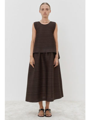 Close-up of MEIMEIJ - PLISSE SKIRT by MEIMEIJ, featuring a textured black fabric with an architectural fine weave pattern.