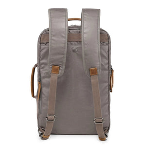 A close-up of the TSD BRAND - MADRONE Coated Canvas Backpack in Grey shows its brown leather accents and an unzipped front pocket with a black wallet partially visible inside.
