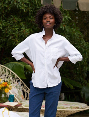 The FRANK & EILEEN Ruffle Eileen Ruffle Collar Button Up Shirt in White Famous Denim features rolled-up long sleeves, a ruffled collar, and a single chest pocket, shown against a white background.