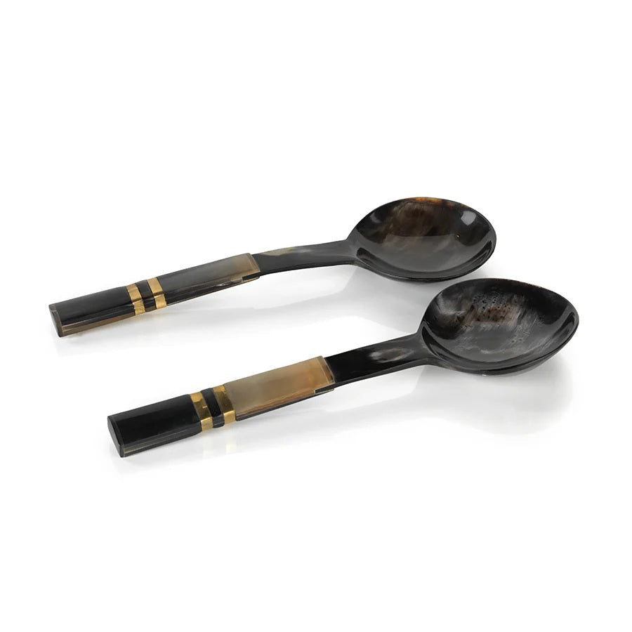 The SEYCHELLES HORN SALAD SERVER SET by ZODAX features two dark-hued serving spoons with round bowls and gold-tan accented handles, ideal for luxury home décor or as an elegant hostess gift. Displayed on a white background.