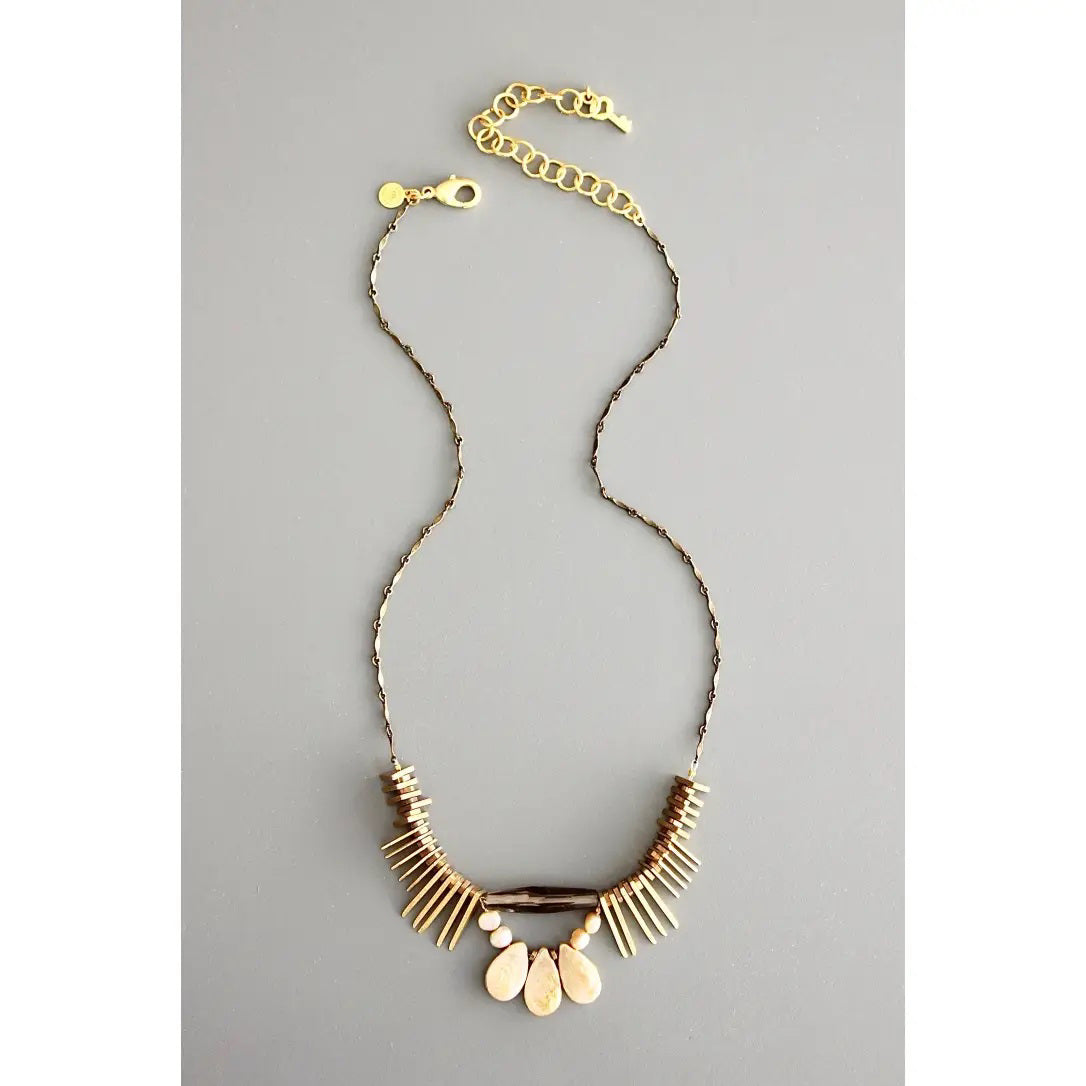 The DAVID AUBREY - ATHENA PEARL SMOKEY QUARTZ NECKLACE features a delicate gold chain, adjustable clasp, and fan-shaped pendant with cream and gold accents—a perfect handcrafted Mother&#39;s Day gift from DAVID AUBREY, shown on a gray background.