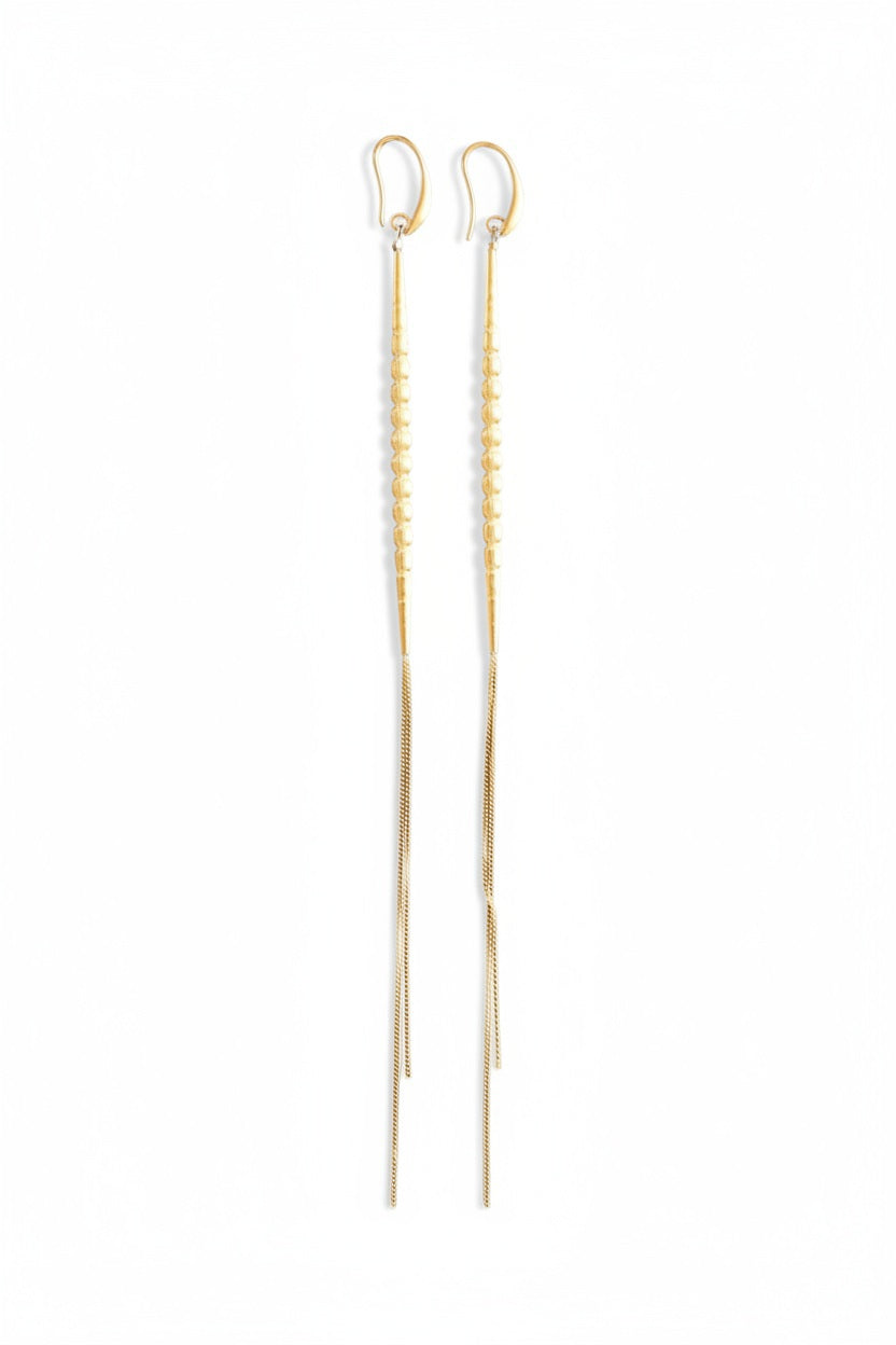 DAVID AUBREY - GOLD PLATED SHOULDER DUSTER EARRINGS feature small round beads and delicate gold-plated chain ends, elegantly displayed on black hexagonal tiles set against a gray background.
