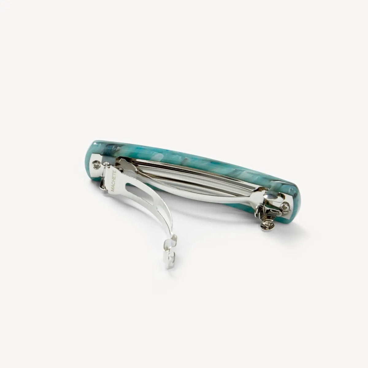 The MACHETE - NO. 3 Heirloom Barrette in Jadeite by MACHETE features a rectangular, rounded-edge handmade design in marbled blue-green cellulose acetate with white streaks, shown on a plain white background.