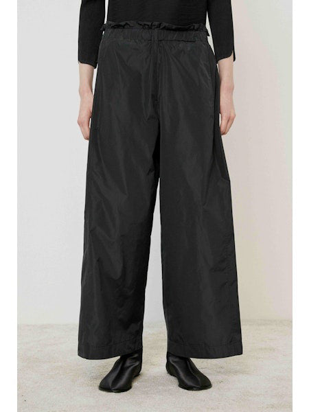 A flat, solid brown surface fills most of the image with a narrow black strip along the bottom edge, evoking the minimalist style of the MEIMEIJ - WIDE LEG PANT by MEIMEIJ.