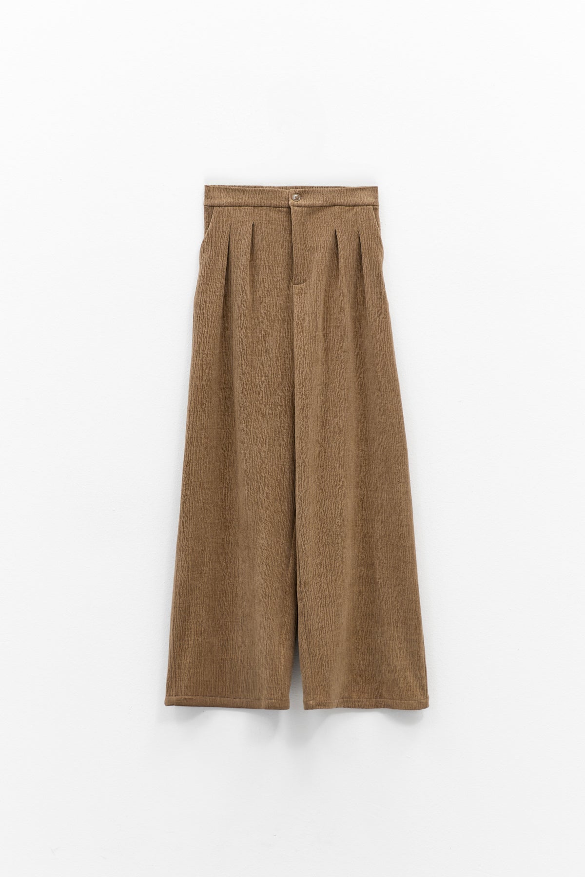 A person wearing ELEH CLASSIC WIDE LEG TROUSERS and a matching brown corduroy jacket, paired with brown shoes and large sunglasses, stands against a plain white background with hands in pockets.