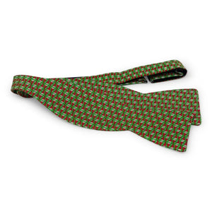 A green silk bow tie with a repeating pattern of red and white Santa hats, handmade in North Carolina by Bird Dog Bay, featuring adjustable neck sizing. The style is the Peter-Blair - Santa Hats Silk Bow Tie in Green.
