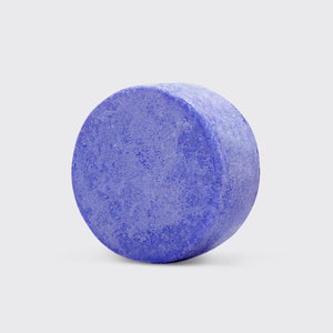 A KITSCH purple toning solid shampoo bar for blonde and highlighted hair, weighing 3.2 oz (91g), sits on its box labeled "KITSCH - Purple Toning Solid Shampoo Bar." It reduces brassiness and is color-safe, pH balanced, and vegan.