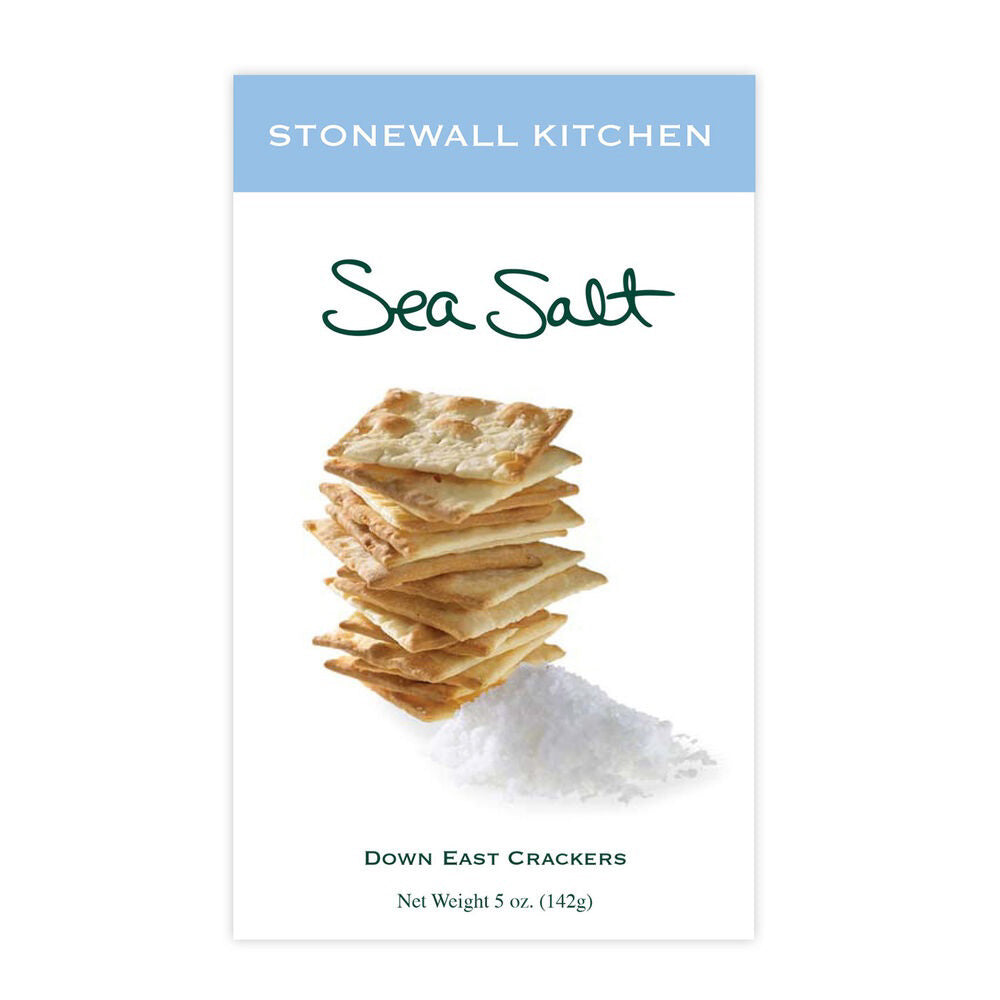 A rectangular package of Stonewall Kitchen - Sea Salt Crackers displays a stack of hand-cut, square-shaped crackers accompanied by a scatter of sea salt. The net weight is 5 oz (142g), and the packaging features an attractive light blue and white design, making it an enticing crisp snack.