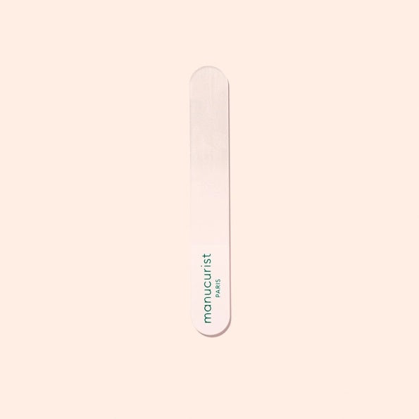 The MANUCURIST - GLASS BUFFER by MANUCURIST INC, shown alongside its rectangular light pink box with green text, is a recyclable premium nail buffer that delivers a flawless, polished-free shine.