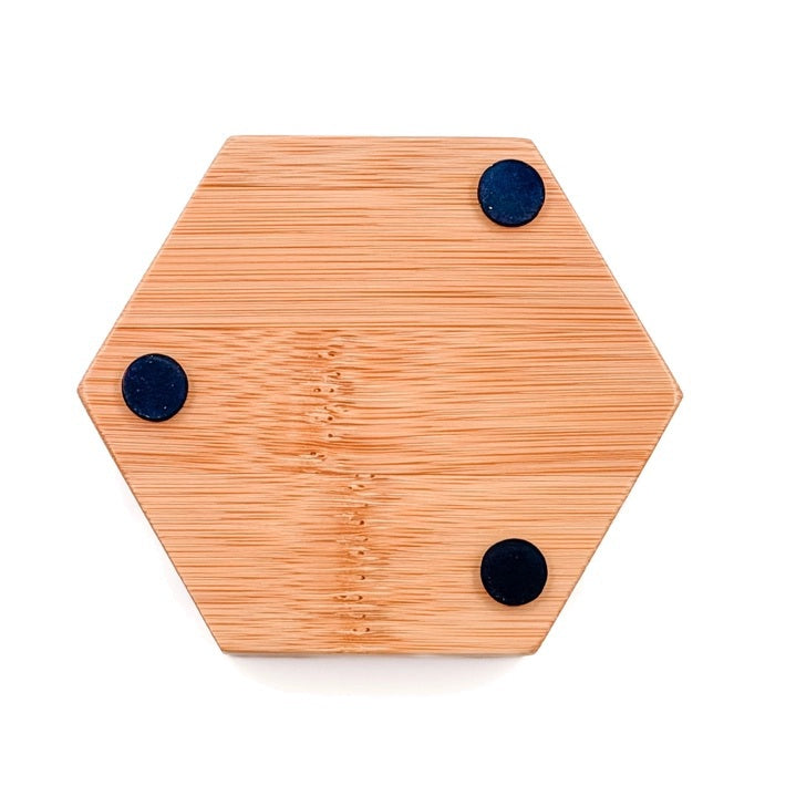 The BAUDELAIRE - BAMBOO HEX SOAP DISH is a hexagonal bamboo soap dish with horizontal grooves and the word “BAUDELAIRE” engraved on the front. Featuring a natural finish, this eco-friendly accessory brings both style and function to your bathroom sink or shower.
