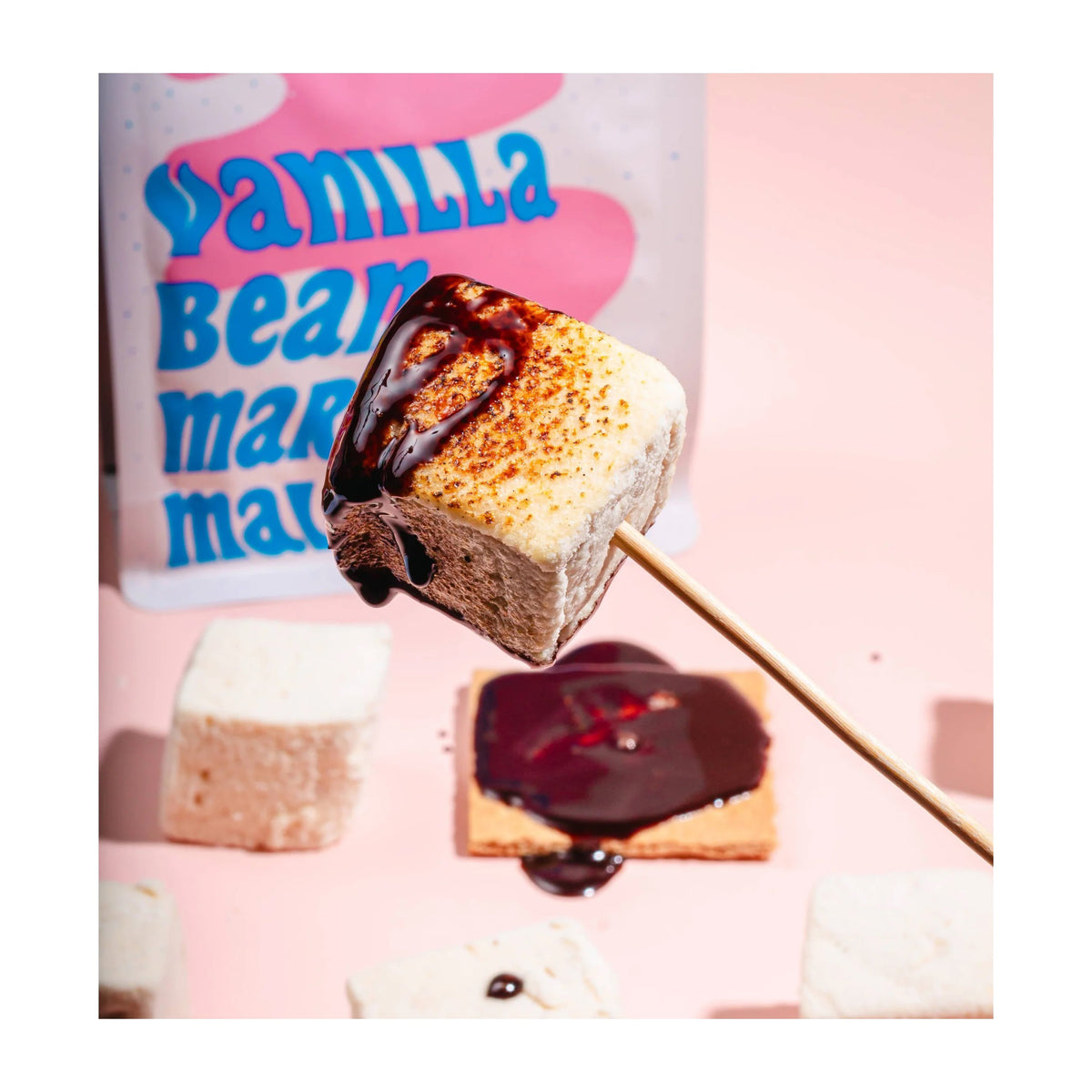 A pastel-colored bag of MOJAVE MALLOWS - VANILLA BEAN MARSHMALLOWS from MOJAVE MALLOWS, featuring bold blue and peach lettering, abstract shapes, and packaging details highlighting that these marshmallows are organic, vegan, toastable, snack-worthy, and handmade.