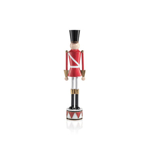 The ZODAX ALLOY FESTIVE DECORATIVE SOLDIER - SHORT features a red uniform with white stripes, black hat and boots, and stands on a round base with a red and white drum pattern; measures 4.5 x 17.75 inches for a striking display.