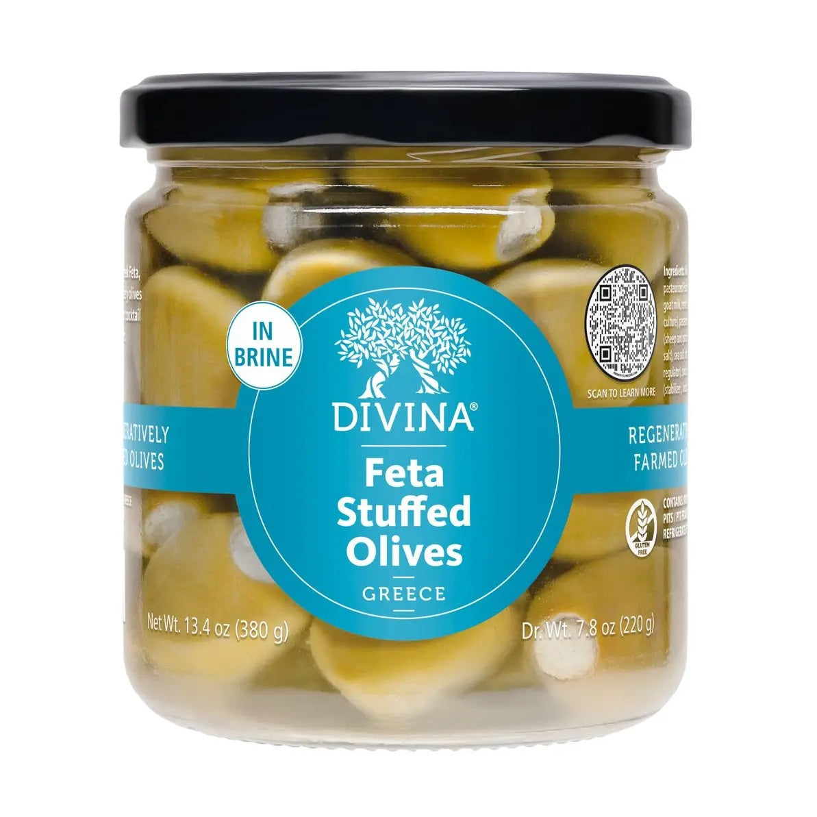A white ramekin filled with DIVINA - FETA STUFFED OLIVES, placed on a wooden surface alongside dishes of sliced cucumbers and cherry tomatoes, creates the perfect appetizer for your cheeseboard.