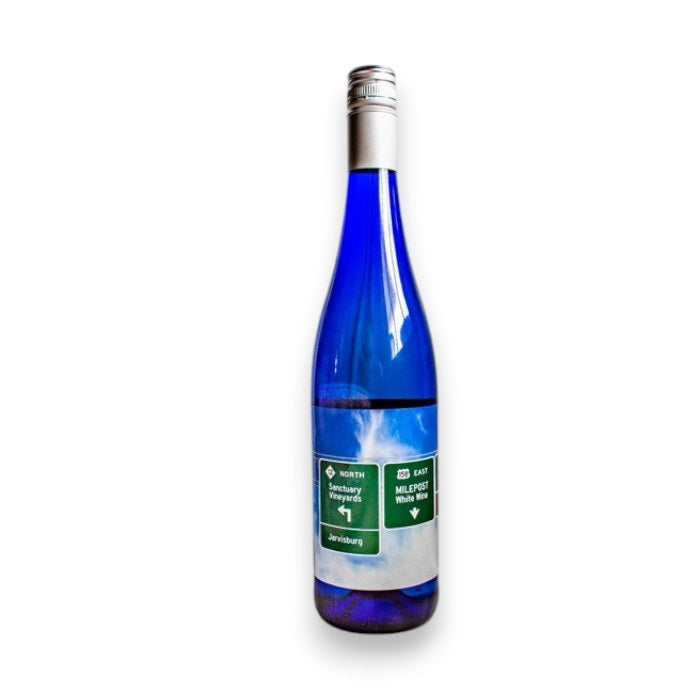 A blue bottle with a silver cap, featuring a green highway sign label to Johannesburg, displays SANCTUARY 'MILEPOST' TRAMINETTE by WINE: FREEDOM BEVERAGE against a plain white background.