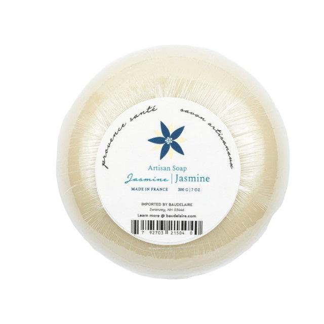 A hexagonal blue box of Baudelaire Jasmine 7 oz Boxed Bath Bar, enriched with shea butter. The box features a large, stylized white flower design and text such as &quot;Jasmine,&quot; &quot;Savor artisanaux,&quot; &quot;Artisan Soap,&quot; and &quot;Made in France.