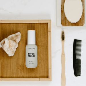 A white bottle labeled "JAXON LANE - SUPER SERUM ULTRA LUMINOUS FACE SERUM FOR MEN," 1 fl oz / 30 ml, with a white cap stands upright on a plain white background—ideal for men seeking a brightening serum with niacinamide.