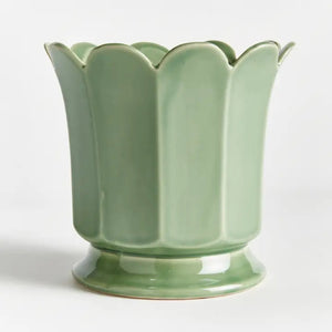 The NAPA HOME AND GARDEN Maline Footed Pot in Green, Large, features a light green ceramic finish with a scalloped, petal-like rim and a flared, rounded base. This elegant vase by NAPA HOME AND GARDEN is photographed against a plain white background.