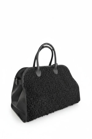 The VICARIO CINQUE - BORUSSIA HANDBAG by VICARIO CINQUE is shown on a white background, featuring a black bouclé-textured exterior on the sides and smooth leather handles.