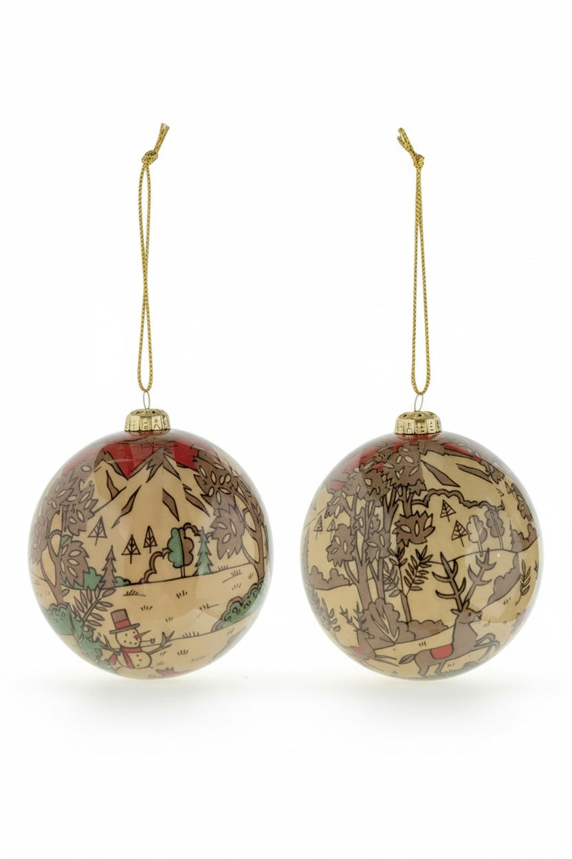 Two round Creative Coop DECOUPAGE BALL ORNAMENT WITH WINTER SCENE glass ornaments featuring a decoupage landscape with trees, a snowman, and a deer, sold individually in assorted styles.