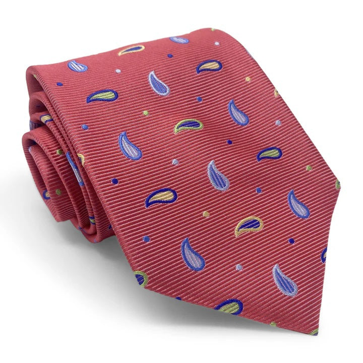 A rolled-up BIRD DOG BAY PETER-BLAIR Bespoke Paisley Soiree Silk Tie in red, featuring blue, yellow, and green paisleys and dots with a subtle diagonal ribbed texture, expertly handmade in New York.