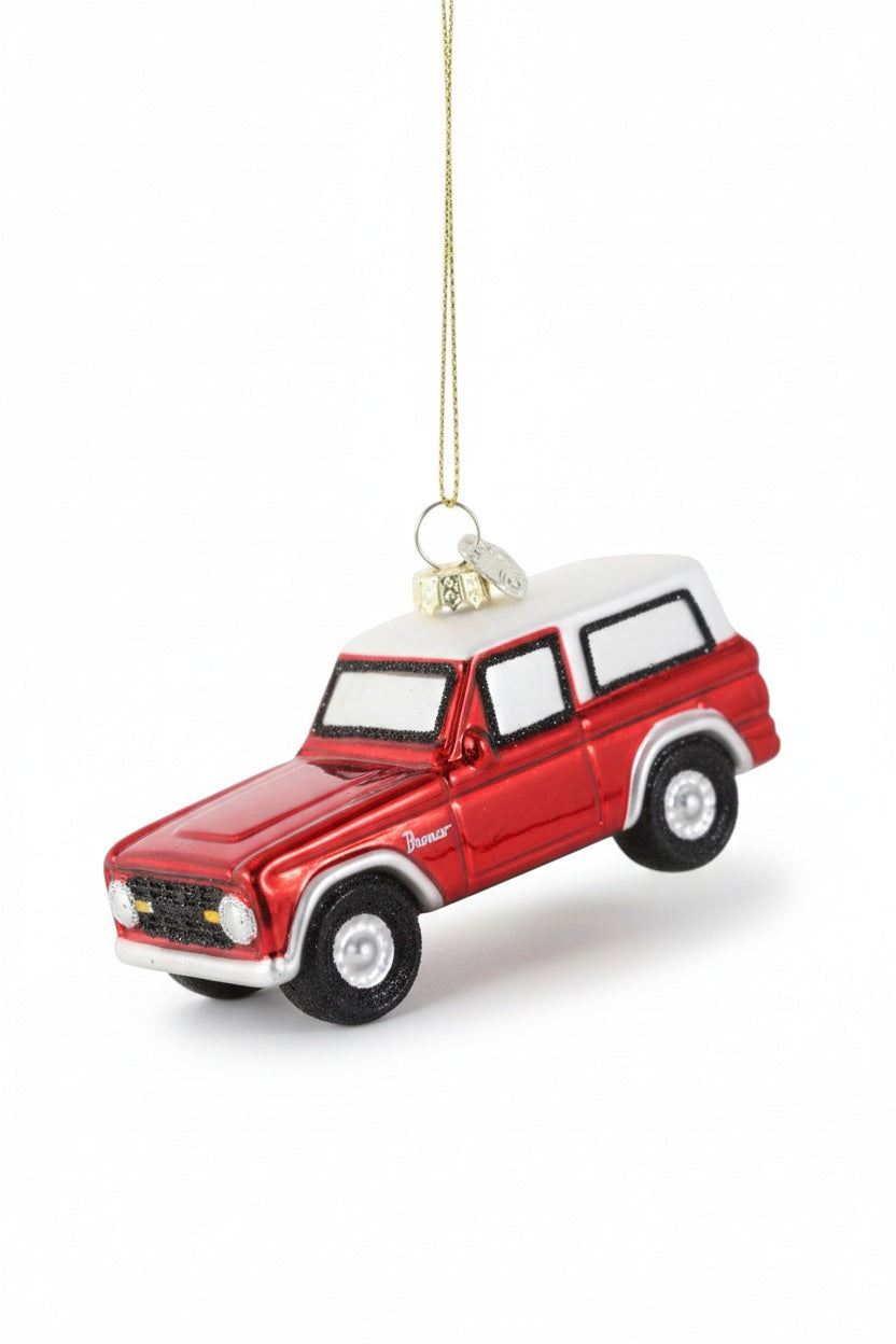 A 4-inch decorative red and white GLASS VINTAGE TRUCK ORNAMENT by Cody Foster, hanging by a gold thread.