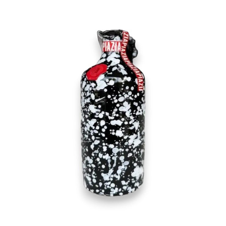 Introducing the GALANTINO - EXTRA VIRGIN OLIVE OIL LIMITED EDITION from ZIA PIA IMPORTS, a hand-painted ceramic bottle adorned with a black background and white splatter pattern. The bottle is sealed with luxurious red wax and features a vibrant red label reading "Zia Pina dalla Puglia," celebrating the rich heritage of the Puglia region. Ideal for storing premium extra virgin olive oil.