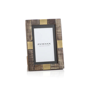 The ZODAX LAGOS HORN AND BRASS PHOTO FRAME 4x6 features a ribbed, brown and gold design, displaying a "ZODAX" placeholder for 4x6-inch photos. This elegant frame stands upright on a white background.