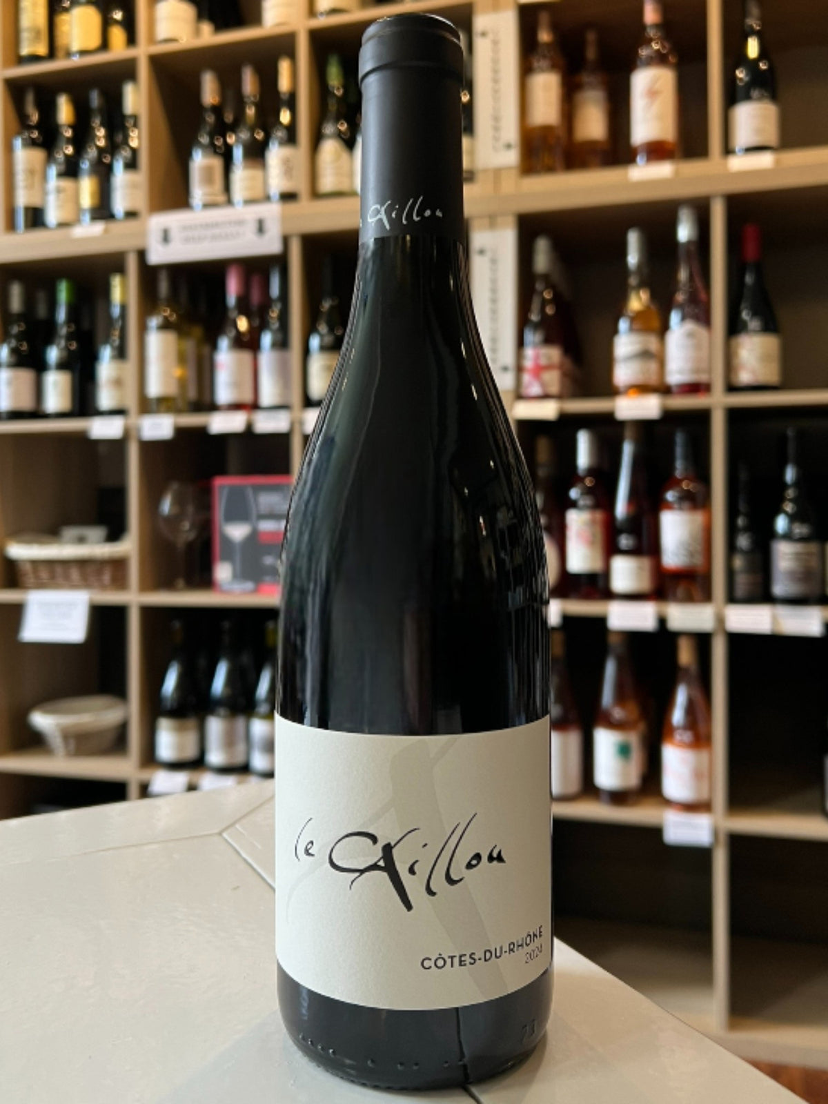 A dark glass wine bottle with a black cap and a white label reading “LE CLOS DU CAILLOU 'LE CAILLOU ROUGE' 2024” from WINE: KELLOGG SELECTIONS stands upright, presenting this classic Southern Rhône wine against a white background.