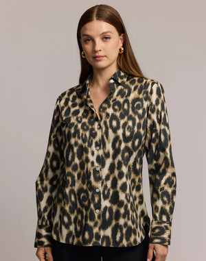 A woman with straight brown hair and gold hoop earrings is seen from the back, modeling the HINSON WU - MARGOT LONG SLEEVE SHIRT IN ANIMAL PRINT against a neutral background.