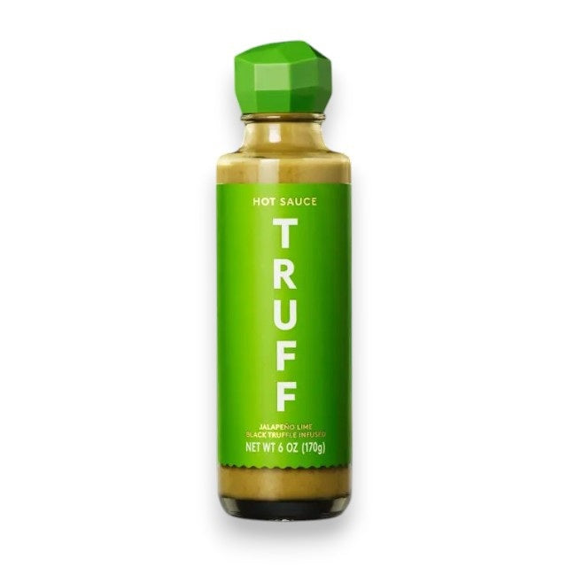 A bottle of TRUFF HOT SAUCE’s JALAPENO LIME HOT SAUCE, featuring a green label and cap marked “Jalapeño Lime,” stands upright on a white background, delivering a fresh twist on the classic TRUFF flavor.