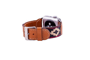 The LA MATERA - CORBINA Apple Watch Band in silver pairs artisan brown leather with a black fabric section, beige geometric pattern, and red stitching.